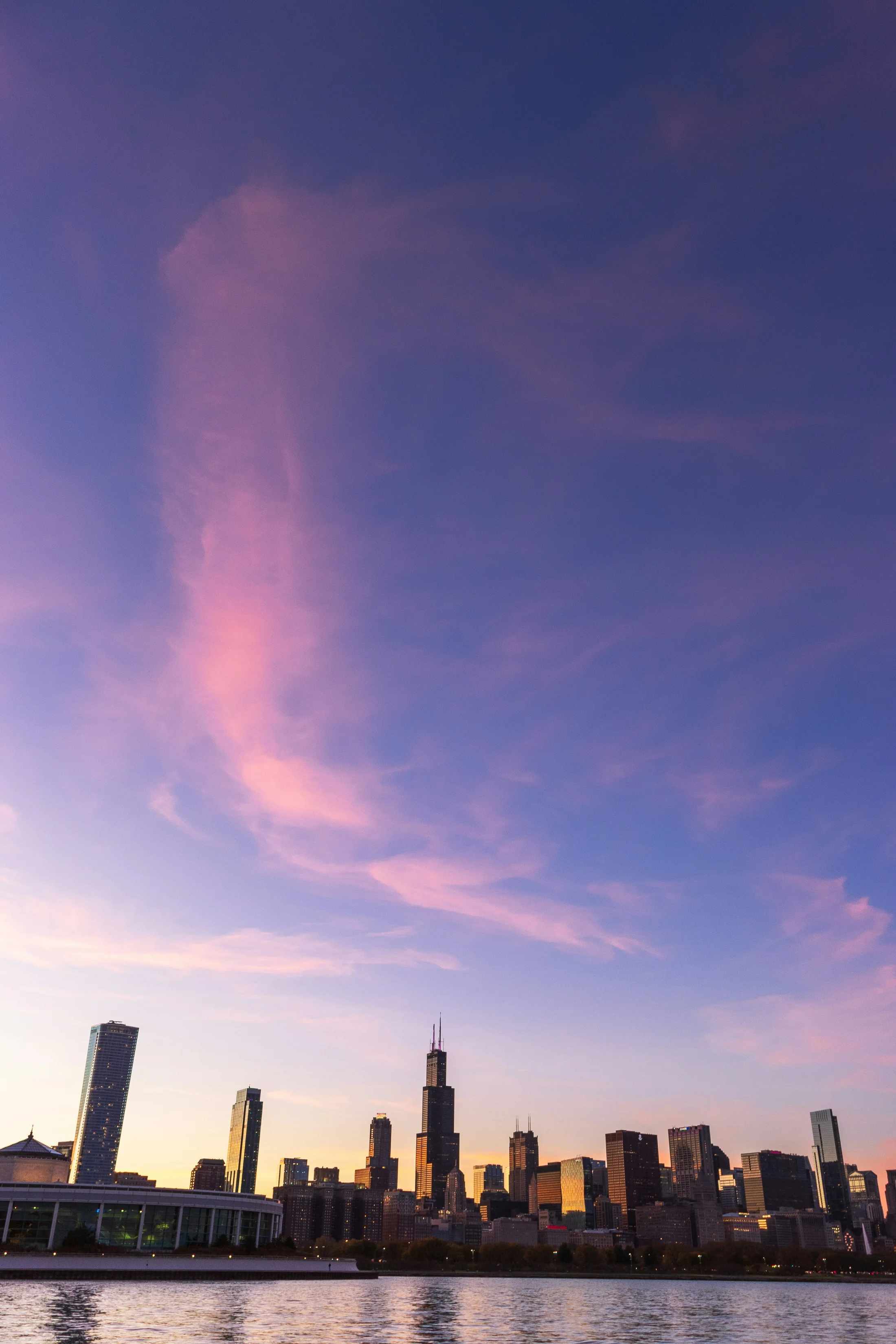 Chicago skyline and Willis Tower across Lake Michigan at sunset